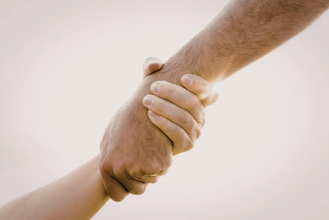 Twee handen die elkaar stevig vasthouden, als symbool voor vertrouwen en samenwerking.